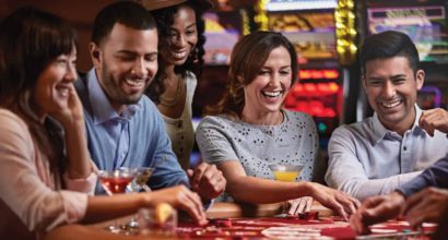 people laughing around a casino table