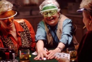an elder woman smiling while holding poker chips