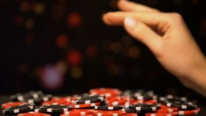 a female hand above a pile of casino chips